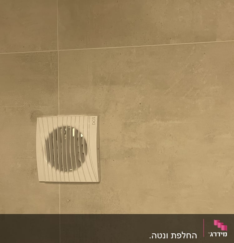 מאוורר קיר לבן מותקן על קיר בטון